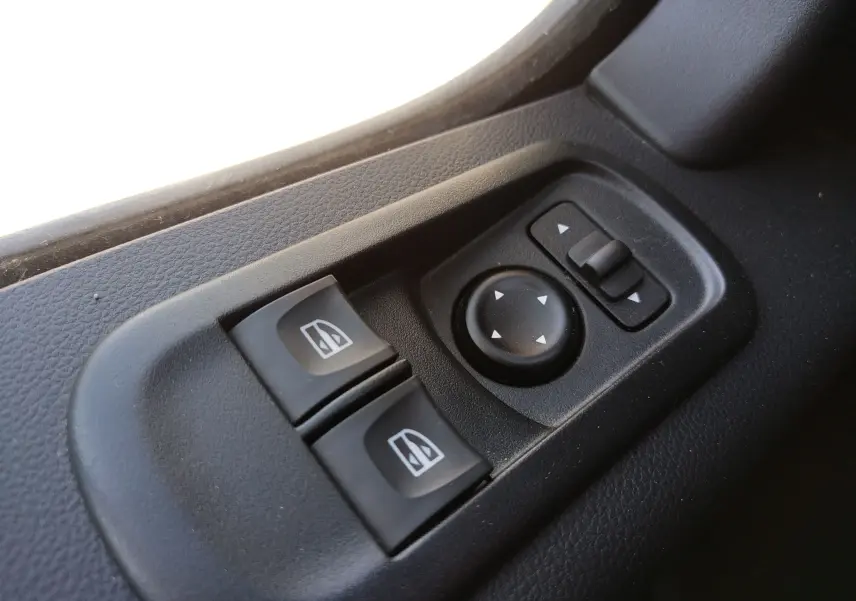 Gros plan sur les commandes électriques des vitres et des rétroviseurs côté conducteur du Renault Master blanc de 2020.