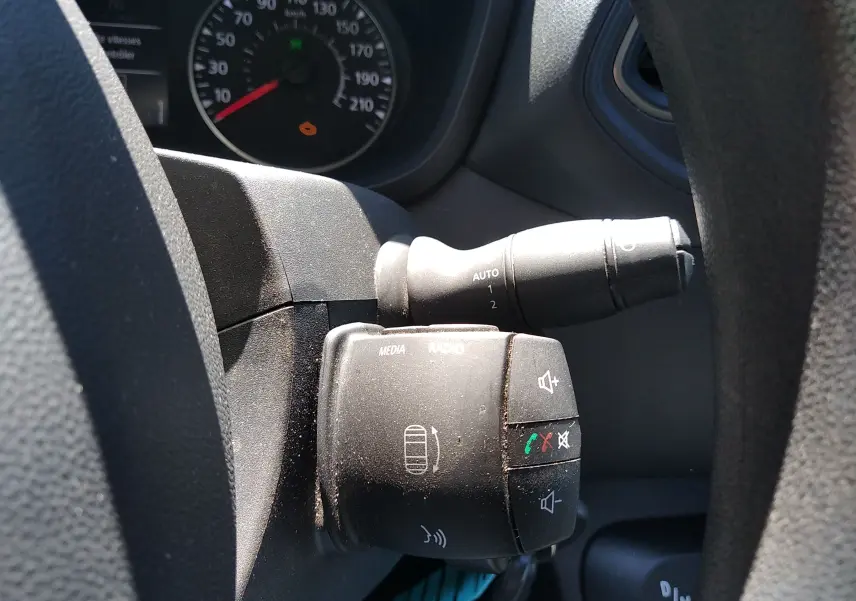 Gros plan sur les commandes au volant du Renault Master blanc 2020, avec régulateur et boutons média visibles.