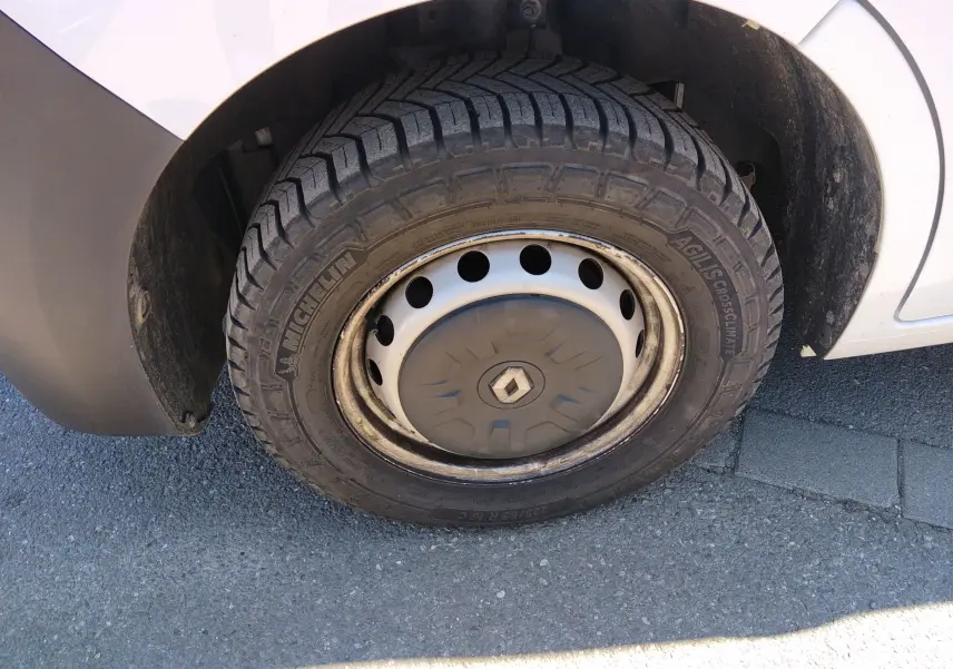 Gros plan sur la roue avant gauche blanche d’un Renault Master III avec jante acier et logo Renault central.