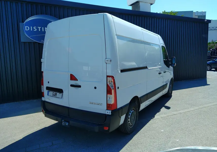 Renault Master blanc vu en 3/4 arrière droit, avec hayon fermé et attelage visible sous le pare-chocs.