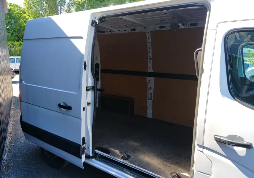Vue latérale droite d’un Renault Master blanc 2020 avec porte coulissante ouverte montrant l’espace de chargement vide.