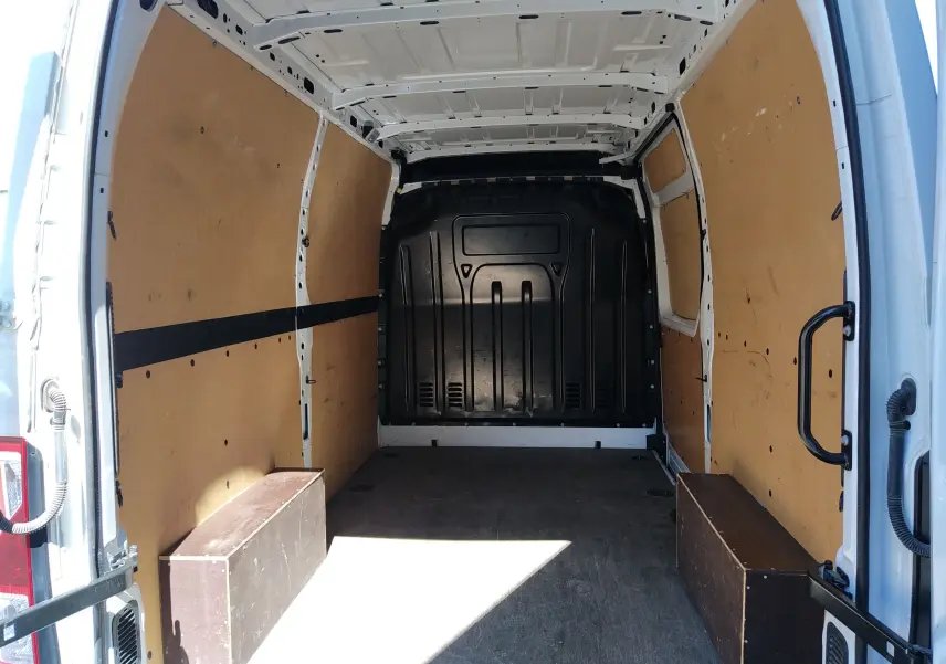Vue intérieure arrière du Renault Master blanc 2020, montrant l'espace de chargement avec parois en bois et plancher sombre.