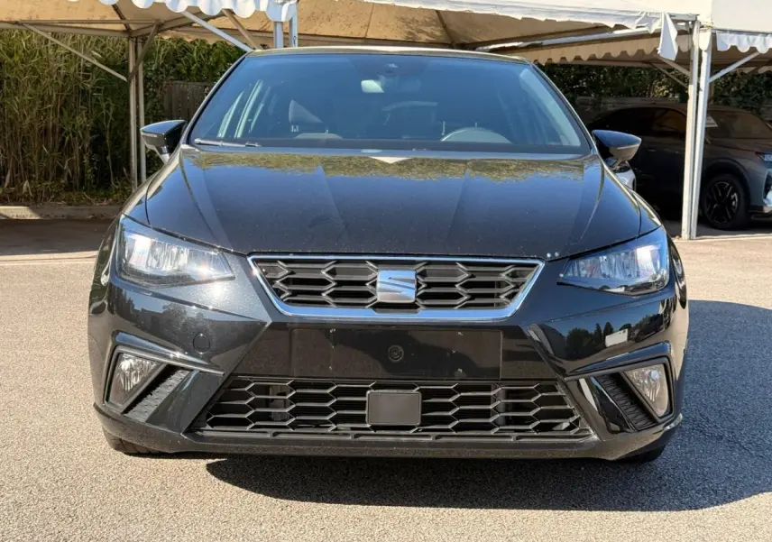 SEAT Ibiza 1.0 TSI 95 FR noire vue en 3/4 avant droit, avec jantes argentées et phares LED allumés.