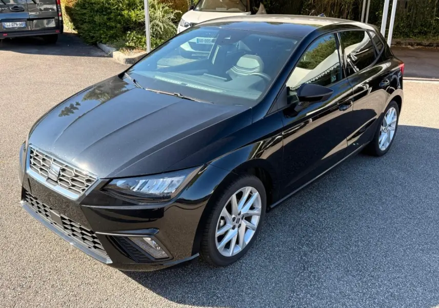 Profil latéral droit d'une SEAT Ibiza noire 2025 avec jantes alliage et vitres teintées, stationnée en extérieur.