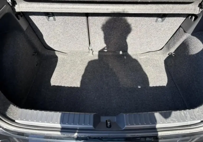 Vue plongeante sur le coffre vide gris foncé d'une SEAT IBIZA 2025 noire, avec banquette arrière rabattue.