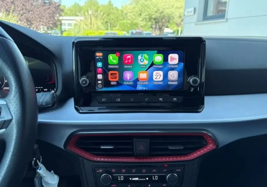 Vue intérieure centrée sur l’écran tactile multimédia de la SEAT Ibiza 2025 avec tableau de bord noir et détails rouges.