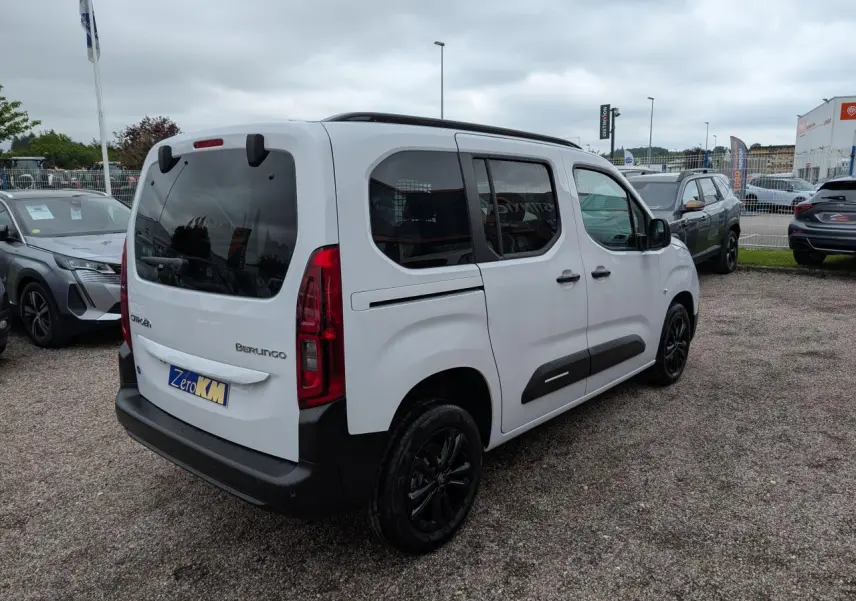 Vue 3/4 arrière droite d'un Citroën Berlingo blanc avec vitres surteintées et jantes alliage noires.