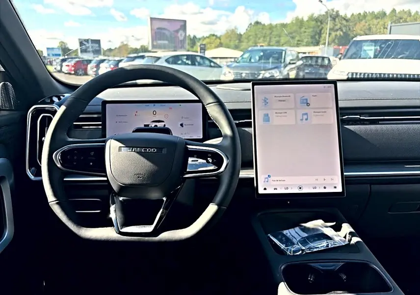 Vue intérieure centrée sur le volant et l'écran tactile vertical du tableau de bord du JAECOO J7 2026.