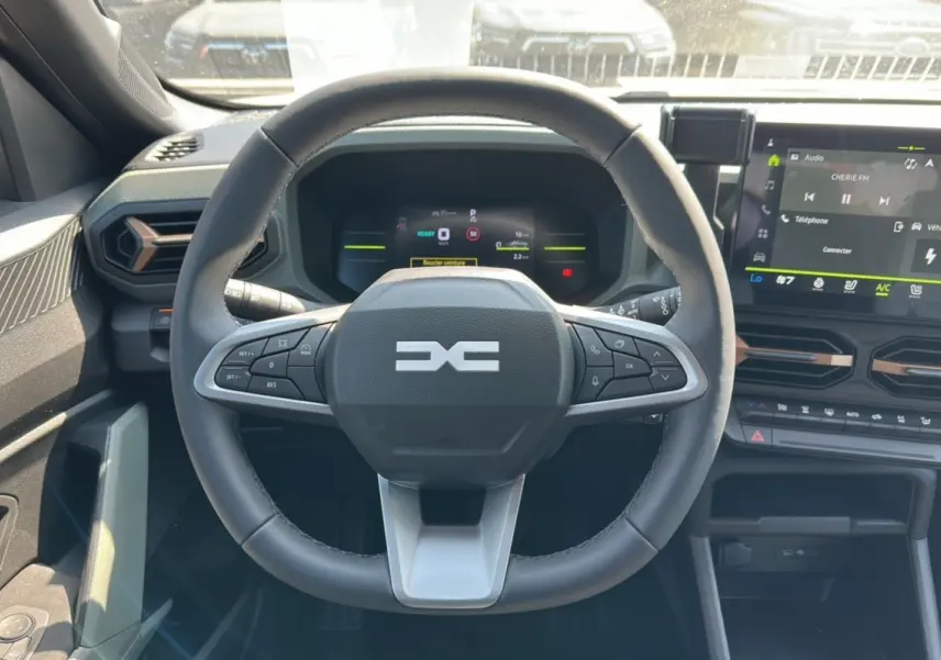 Vue intérieure centrée sur le volant du Dacia Duster HEV 140 Extreme Pack Hiver 2025 avec tableau de bord numérique.