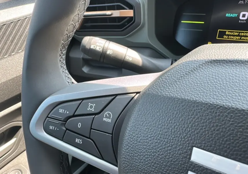 Vue rapprochée du volant du Dacia Duster HEV 140 Extreme Pack Hiver 2025, montrant les commandes côté gauche.