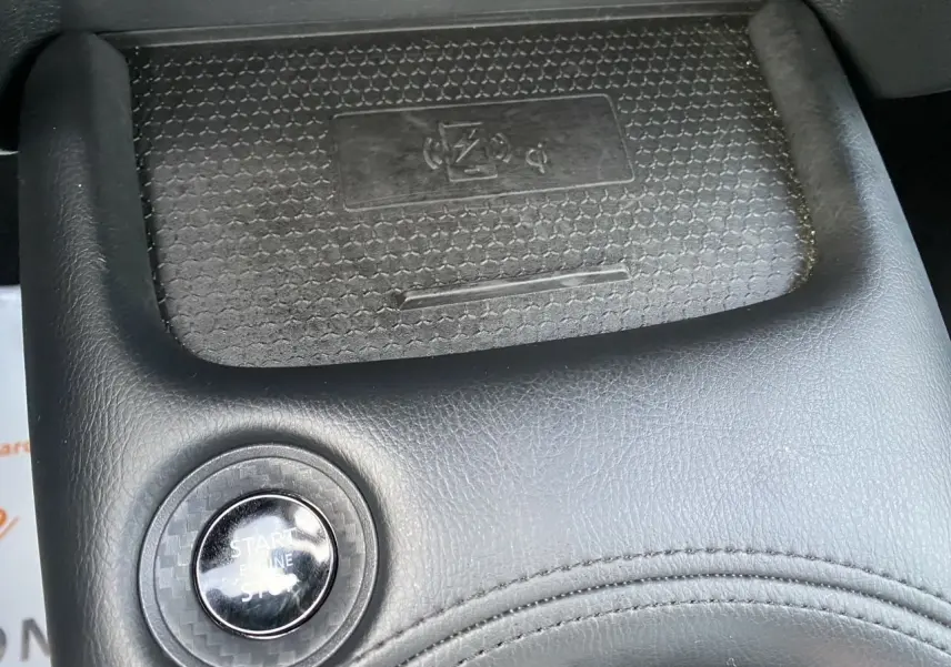 Gros plan sur le bouton Start/Stop noir entouré de cuir noir dans l’habitacle du Nissan Juke 2025.