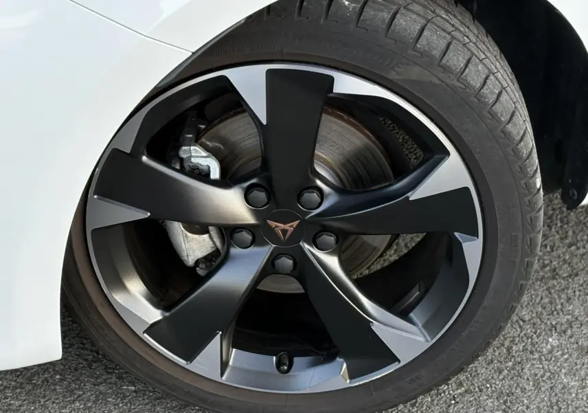 Gros plan sur la jante alliage 18'' Performance usinée noire et grise du CUPRA Leon blanc Neige 2025.