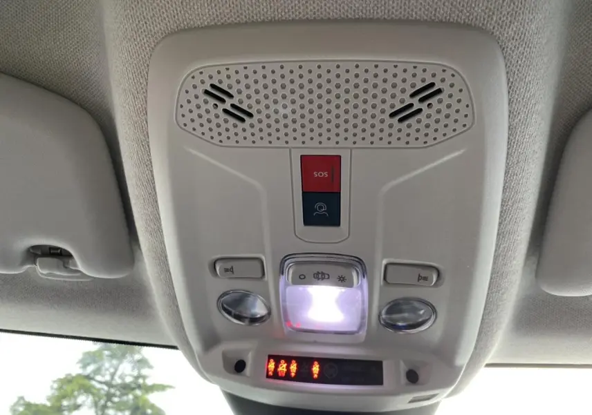 Vue intérieure en contre-plongée du plafonnier gris clair avec boutons SOS et éclairage dans une Citroën C4 bleu Iceland.