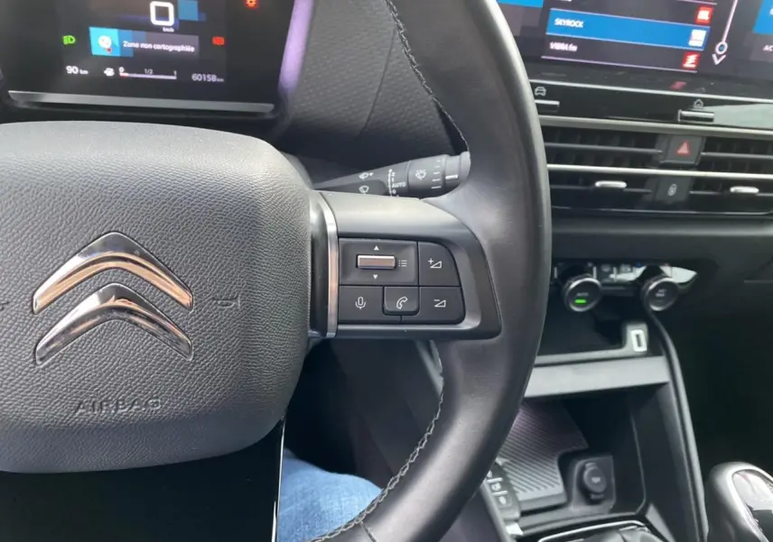 Vue rapprochée du volant et tableau de bord noir de la Citroën C4 2021 avec commandes multifonctions et écran tactile.