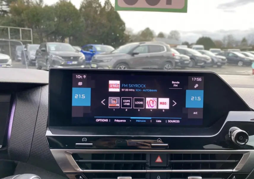 Vue intérieure centrée sur l’écran tactile du tableau de bord de la Citroën C4 2021, avec affichage radio FM et commandes climatisation.