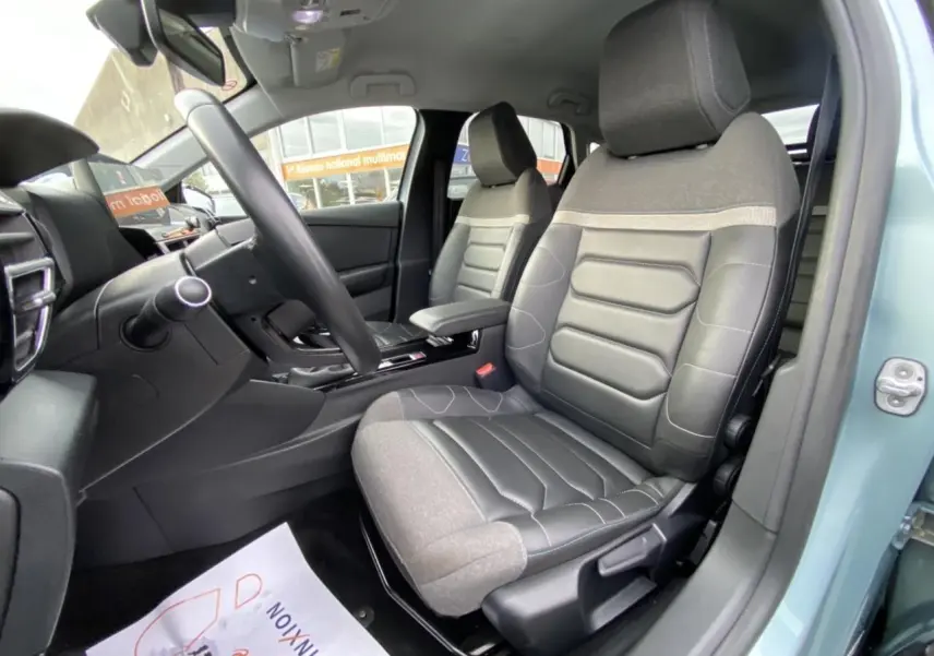 Vue intérieure côté conducteur de la Citroën C4 2021 bleu Iceland, sièges bi-matière gris et noir, tableau de bord visible.
