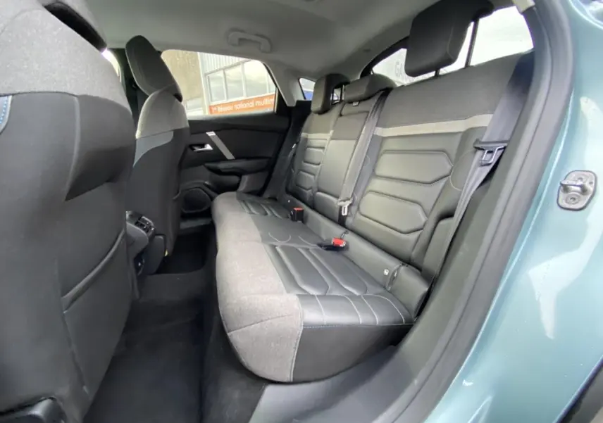 Vue intérieure côté arrière droit du Citroën C4 bleu Iceland montrant la banquette arrière en tissu et cuir noir.