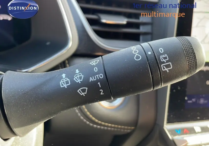 Gros plan sur la commande d’essuie-glace noire dans l’habitacle du Renault Symbioz gris, avec tableau de bord partiellement visible.