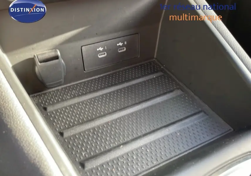 Gros plan sur la console centrale noire avec ports USB-C doubles et prise 12V dans une Renault Symbioz gris cassiopée.