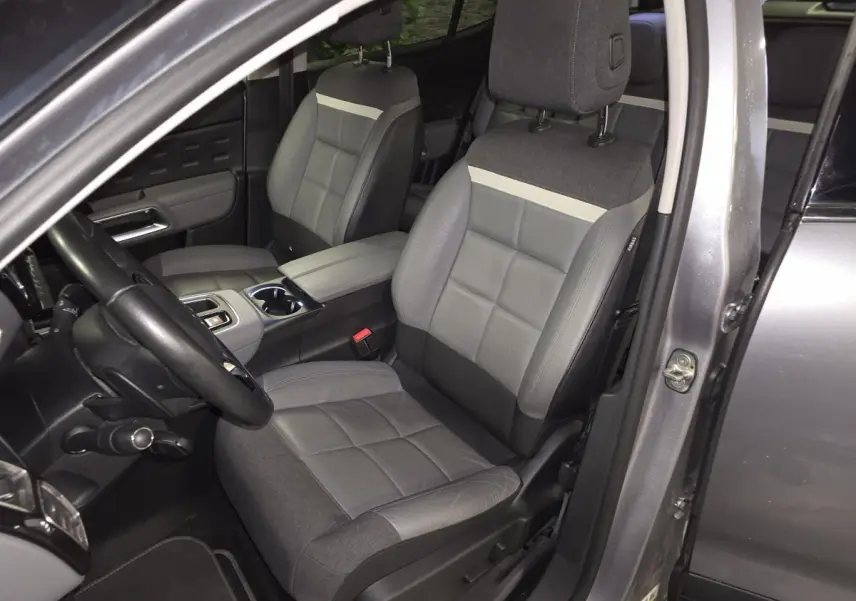 Vue intérieure côté conducteur du Citroën C5 Aircross gris, sièges cuir grainé et tissu gris avec console centrale ouverte.