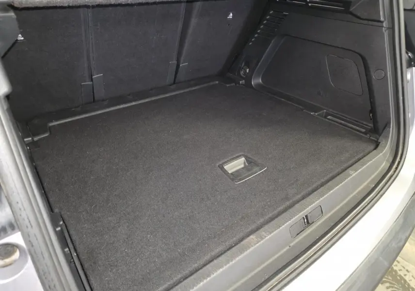 Coffre ouvert vu de l'arrière du Citroën C5 Aircross gris, montrant la surface de chargement plate et noire.