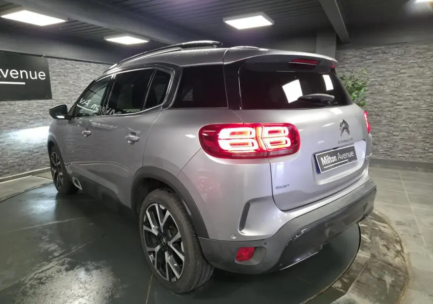 Vue 3/4 arrière droite d'un Citroën C5 Aircross gris métallisé avec feux arrière LED et jantes alliage 19 pouces.