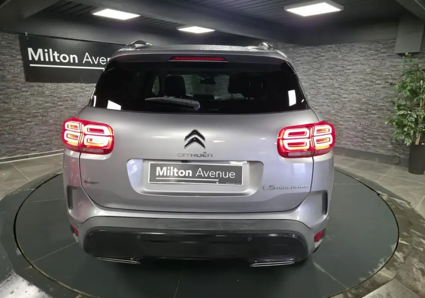Vue arrière d'un Citroën C5 Aircross gris métallisé avec feux arrière LED et double sortie d'échappement.