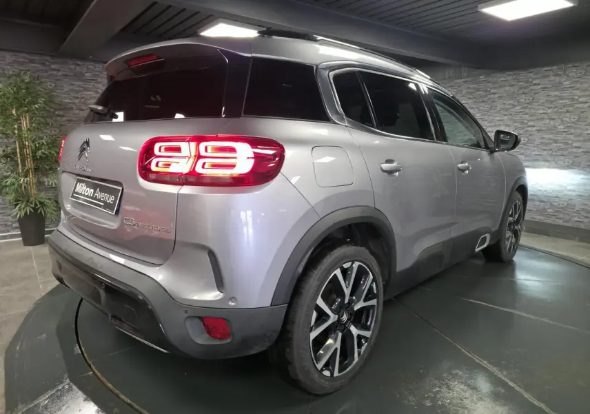 Vue 3/4 arrière droite d'un Citroën C5 Aircross gris métallisé avec feux arrière LED distinctifs et jantes alliage 19 pouces.