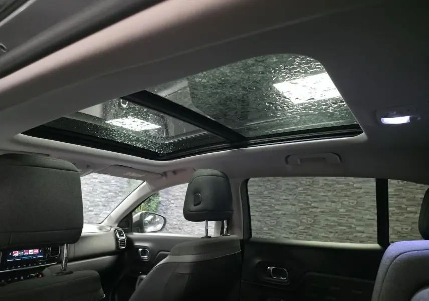 Vue intérieure arrière du Citroën C5 Aircross 2019, toit ouvrant panoramique et sièges en cuir gris visibles.