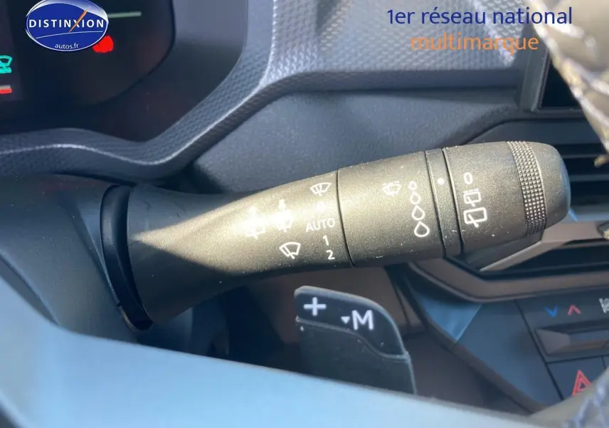 Gros plan sur la commande d’essuie-glace à gauche du volant du Dacia Duster 2026, intérieur noir et gris.
