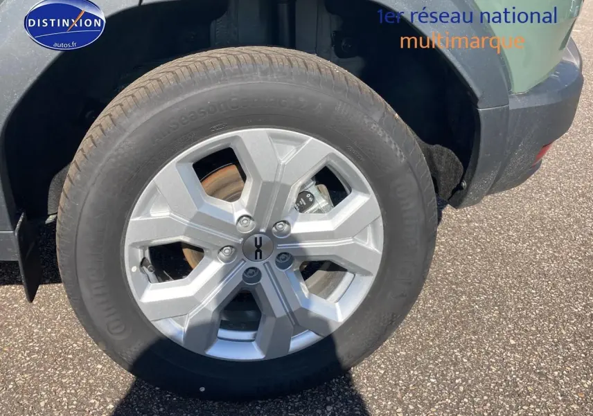 Gros plan sur la roue avant gauche avec jante alu du Dacia Duster 1.2 hybrid-g 150 kaki lichen 2026.