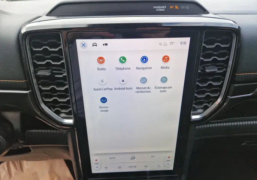 Vue rapprochée de l’écran tactile central du Ford Ranger Wildtrak 2023, avec interface multimédia et aérateurs noirs hexagonaux.