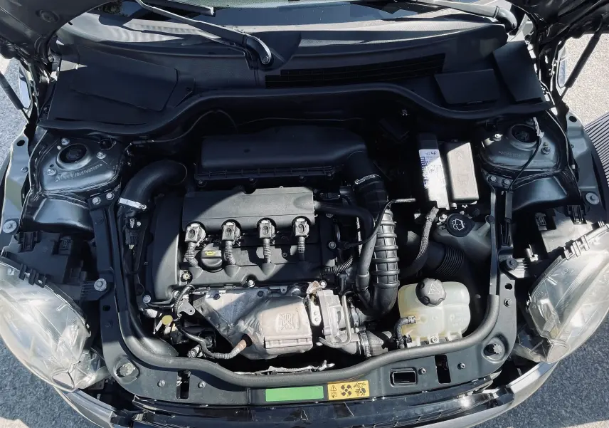 Moteur de la MINI Cooper S gris 2008 vu de dessus, capot ouvert, montrant les composants du compartiment moteur.