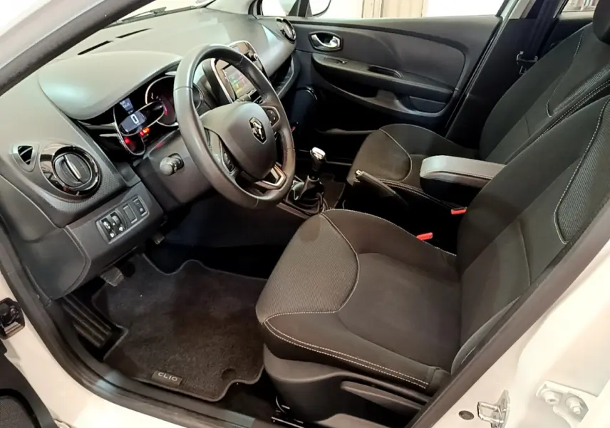Intérieur avant droit d'une Renault Clio Business TCe 90 blanche, volant cuir, tableau de bord avec écran tactile et boîte manuelle.