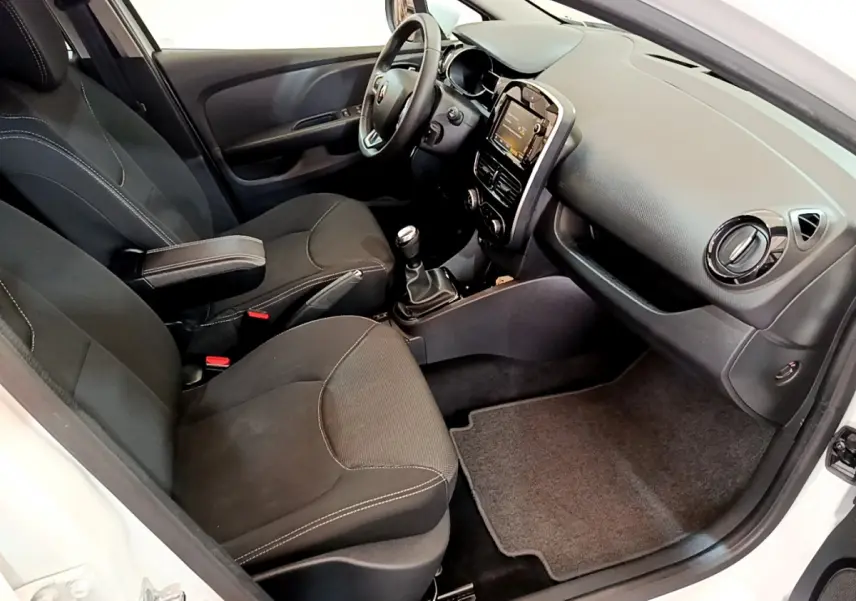 Intérieur de Renault Clio Business TCe 90 2019 blanc, vue côté conducteur montrant sièges noirs et tableau de bord avec écran tactile.