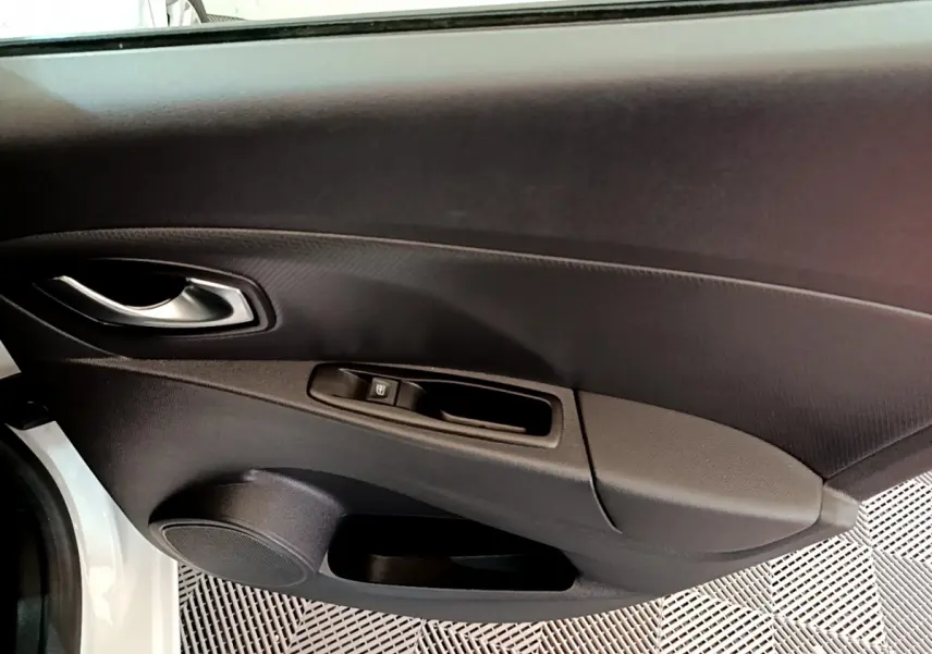 Vue intérieure du panneau de porte côté conducteur de la Renault Clio Business TCe 90 blanc, 2019, avec poignée argentée et commande de vitre.