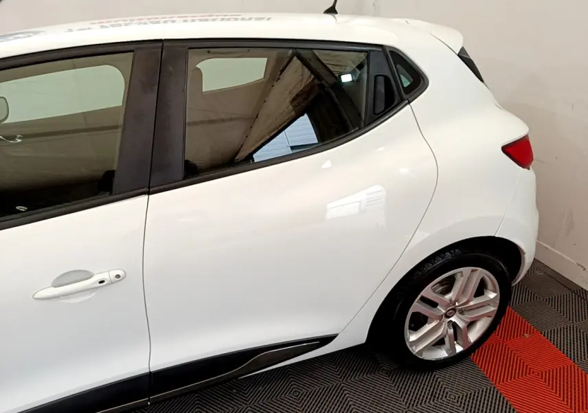 Profil arrière droit d'une Renault Clio Business TCe 90 blanche, mettant en valeur la porte arrière et la jante alliage.