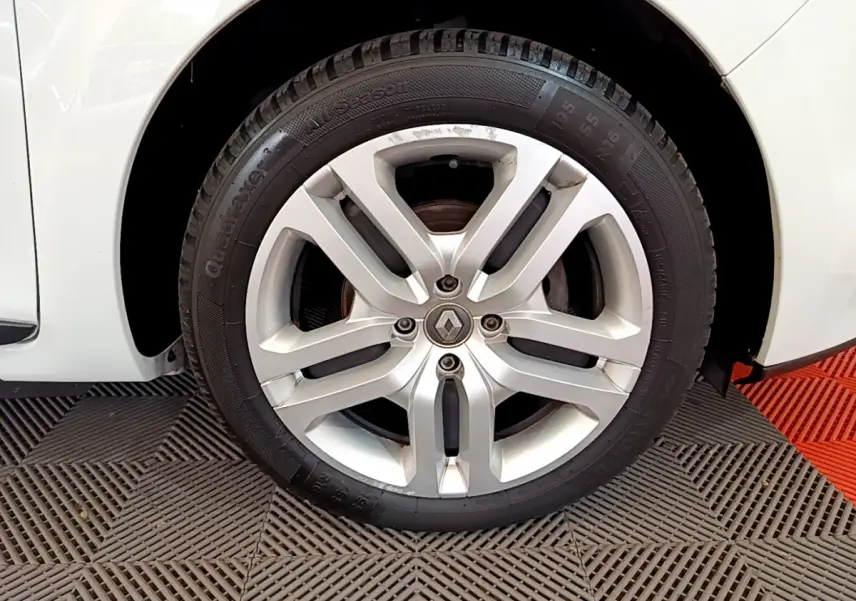 Gros plan sur la roue avant droite blanche d'une Renault Clio Business TCe 90 de 2019 avec jante alliage argentée.