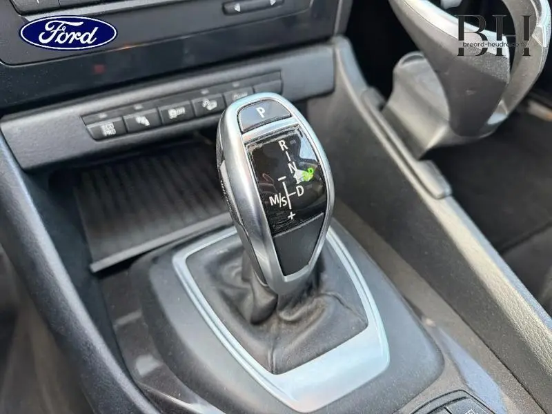 Levier de vitesse automatique en gros plan dans l'habitacle d'une BMW X1 Mineralgrau de 2014.