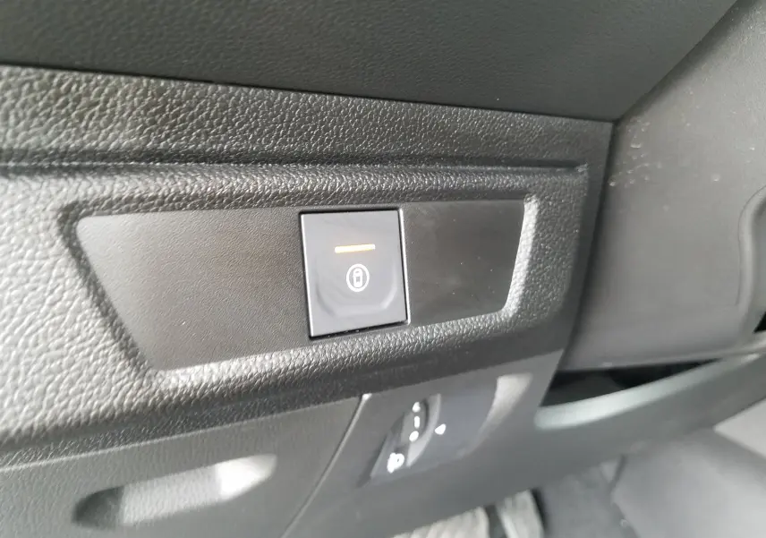 Bouton de verrouillage centralisé éclairé sur la planche de bord intérieure d'une Dacia Sandero Stepway 2025.