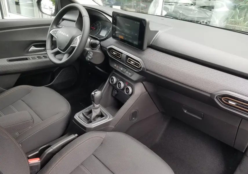 Intérieur avant droit du Dacia Sandero Stepway 2025, tableau de bord moderne avec écran tactile et volant multifonction.