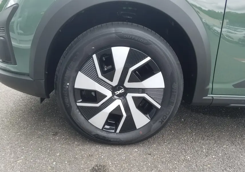 Gros plan sur la roue avant gauche de la Dacia Sandero Stepway 2025 en Licken Kaki avec jante au design moderne noir et argent.