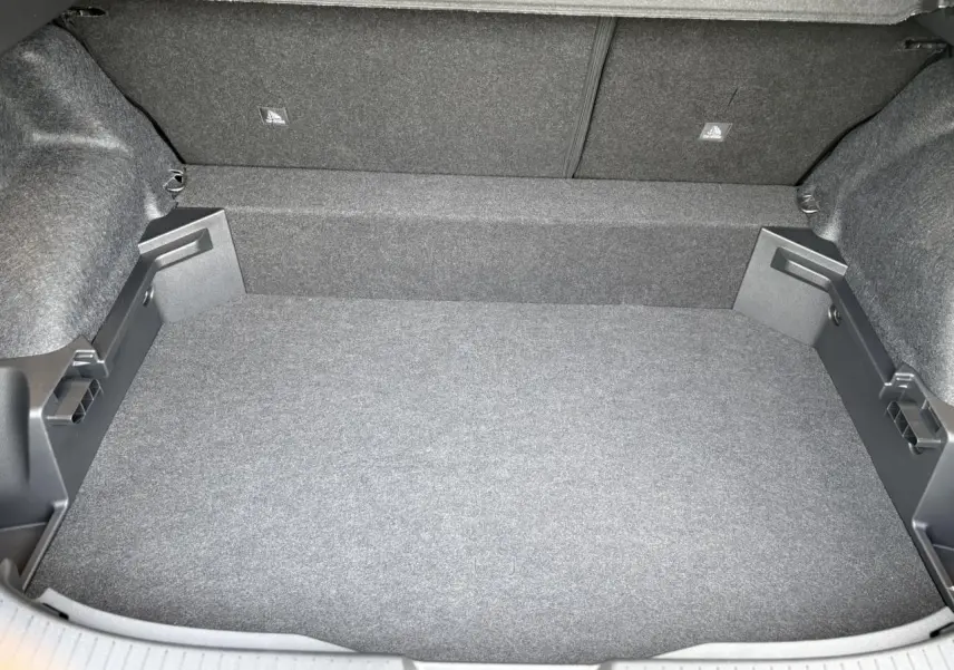 Coffre spacieux et vide du Nissan Qashqai III e-Power 2025, vue de dessus avec revêtement gris uniforme.