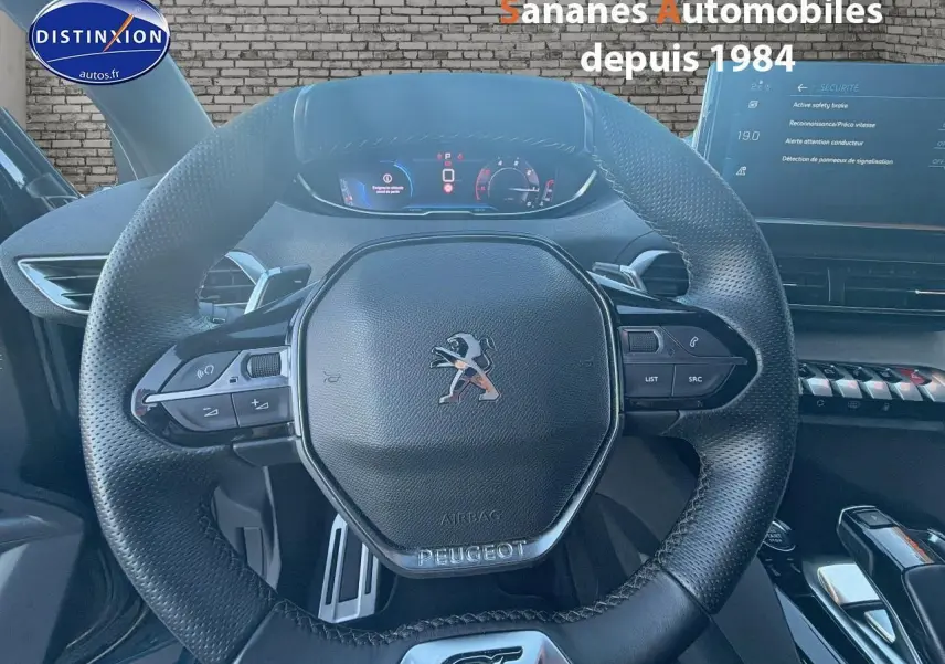 Vue rapprochée du volant cuir perforé Peugeot 3008 GT 2023 avec commandes intégrées et tableau de bord digital.