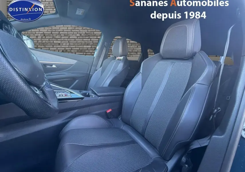 Intérieur de la Peugeot 3008 bleu, vue côté conducteur sur les sièges en cuir noir et volant perforé.