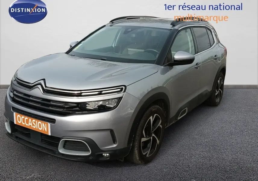 Vue 3/4 avant droit d'un Citroën C5 Aircross gris Artense métallisé avec jantes noires et toit noir.