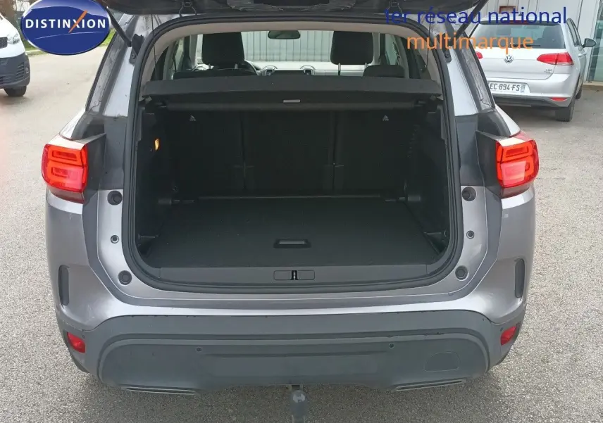 Vue arrière ouverte du coffre d'un Citroën C5 Aircross gris Artense métal, montrant l'espace de chargement vide.