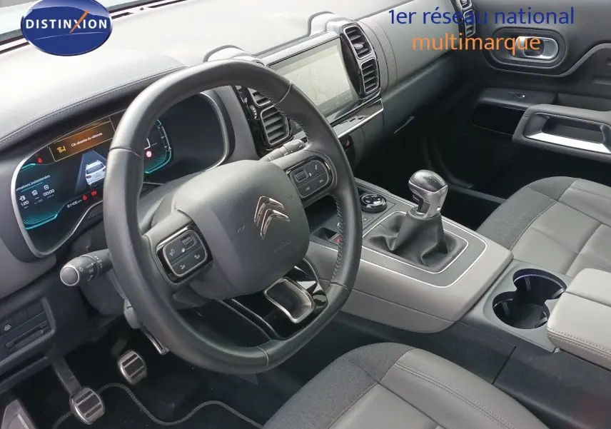 Vue intérieure côté conducteur du Citroën C5 Aircross 1.5 BlueHDi 130ch Shine, avec volant cuir et levier de vitesse manuel.