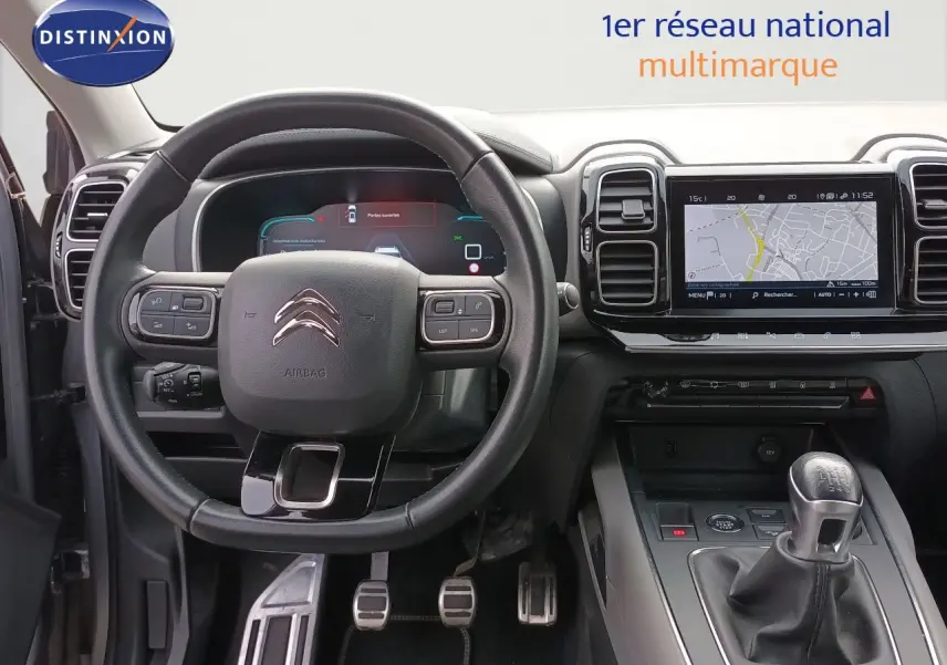 Vue intérieure centrée sur le volant et la console centrale avec levier de vitesse manuel du Citroën C5 Aircross gris 2020.
