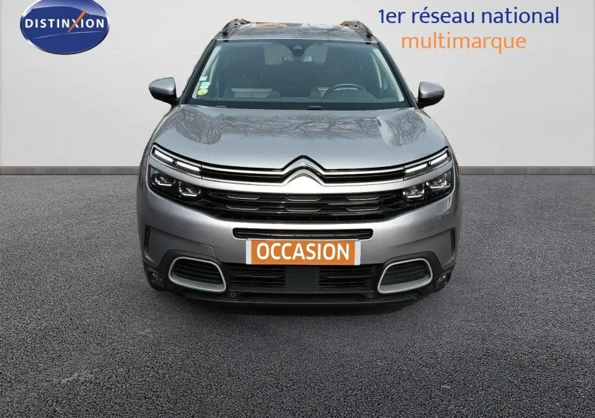 Vue frontale d'un Citroën C5 Aircross gris Artense métal avec calandre distinctive et plaque "OCCASION" visible.